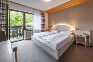a bedroom with a large bed and a large window at Café Pension Leistner in Obertrubach