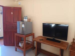 a living room with a flat screen tv and a table at Sapan Residence in Chiang Mai