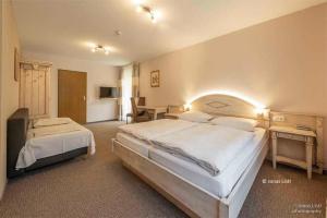 a large bedroom with two beds and a desk at Café Pension Leistner in Obertrubach