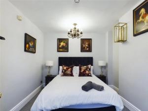 a bedroom with a bed and a chandelier at Montague House Town Centre Sleeps Up To 12 Guests in Ross on Wye
