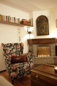 a living room with a chair and a fireplace at Maison de Charme Courmayeur in Courmayeur