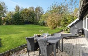 a table and chairs on a patio with a yard at Holiday Home Kalleholled Gudhjem Denm in Gudhjem +14 photos