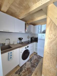 a kitchen with white cabinets and a washer and dryer at Loft piano terra a 300m dal mare in Terracina