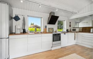une cuisine blanche avec des armoires blanches et une fenêtre dans l'établissement Awesome Home In Gilleleje With Wifi, à Gilleleje