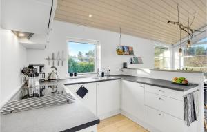 a kitchen with white cabinets and a large window at 2 Bedroom Nice Home In Skibby in Skibby