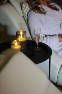a woman sitting on a couch with a table with two candles at WellTime PrivateSpa in Heiligenhaus