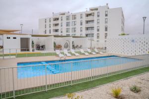 a swimming pool in front of a building at Departamentos Bahia Suites in Bahia Inglesa
