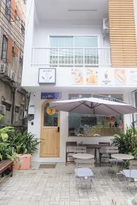 清迈Phak Phing Hostel的一间带遮阳伞和桌椅的餐厅