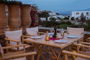 una mesa de madera con una botella de vino y copas en Aspro Villas, en Piso Livadi