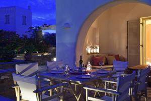 a table and chairs on a patio at night at Aspro Villas in Piso Livadi