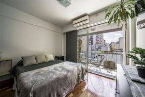 Un dormitorio con una cama y una ventana grande. en Mario Bravo 480 by depptö, en Buenos Aires 27 fotos más