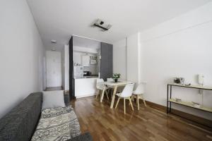 Una sala de estar con una cama, una mesa y sillas. en Mario Bravo 480 by depptö, en Buenos Aires