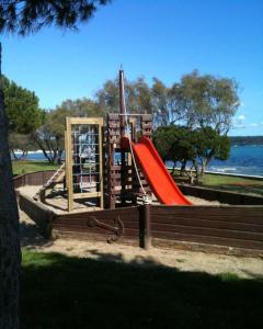 a playground with a red slide in a park at Faber Apartments in Novigrad Istria