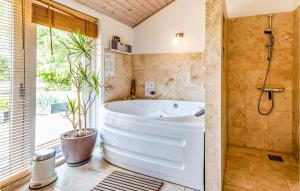 a bathroom with a large tub and a window at Two-Bedroom Holiday Home With A Fireplace In Sjællands Odde in Yderby