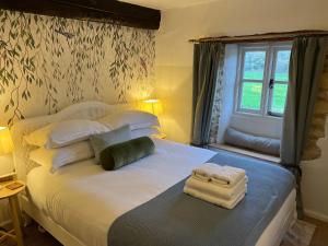Un dormitorio con una cama con toallas. en Meadow View Cottage, en Cheltenham