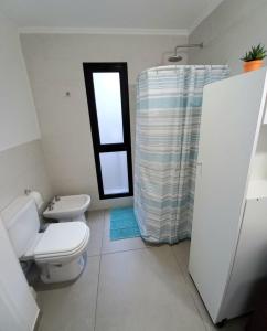 a bathroom with a toilet and a window at El Trébol II in Necochea +12 photos