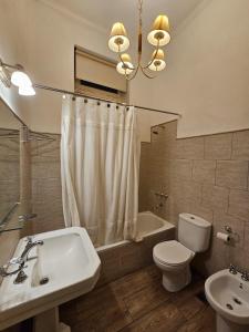 a bathroom with a sink and a toilet and a tub at XIX Century Home in Buenos Aires