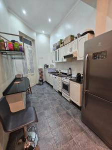 a kitchen with a stainless steel refrigerator and white cabinets at XIX Century Home in Buenos Aires