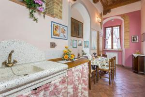 a kitchen and dining room with a table and chairs at Locazione Turistica Totti in San Gimignano