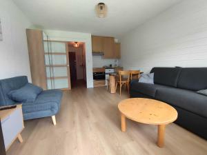 ein Wohnzimmer mit einem blauen Sofa und einem Tisch in der Unterkunft Studio central avec balcon Sud et parking, proche remontées mécaniques - FR-1-692-95 in La Chapelle-dʼAbondance