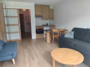 ein Wohnzimmer mit Couch und Tisch und eine Küche in der Unterkunft Studio central avec balcon Sud et parking, proche remontées mécaniques - FR-1-692-95 in La Chapelle-dʼAbondance