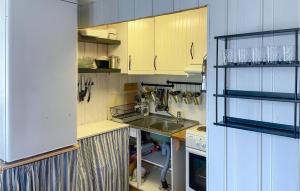 eine kleine Küche mit gelben Schränken und einem Waschbecken in der Unterkunft Amazing Home In Østby in Østby