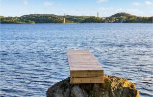 una piattaforma di legno su una roccia su uno specchio d'acqua di The Woodpecker Cottage Tree a Salterød