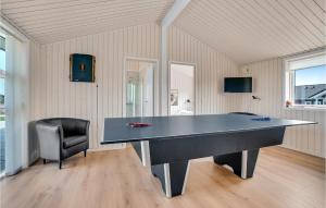 a large ping pong table in a room with a chair at Lovely Home In Løkken With Sauna in Løkken