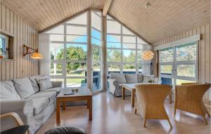 a living room with a couch and tables and windows at Holiday Home Toftevej Løkken V in Løkken