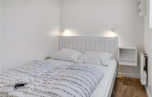 a bedroom with a white bed with two pillows at Awesome Apartment In Væggerløse in Marielyst