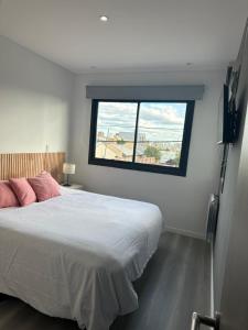 Un dormitorio con una cama grande y una ventana. en LEVEL TERRAZAS exclusivo con parrillas privadas, en Bahía Blanca