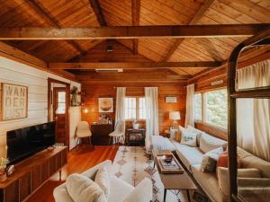 a living room with a couch and a tv at The Little Lake Cabin in New Fairfield