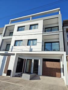 un edificio de apartamentos blanco con garaje en LEVEL TERRAZAS exclusivo con parrillas privadas, en Bahía Blanca 19 fotos más