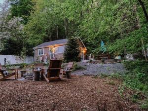 a cabin in the woods with lights on it at The Little Lake Cabin in New Fairfield