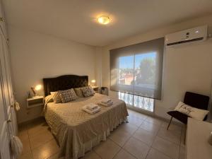 a bedroom with a bed and a large window at En el Corazón de la Quinta. in Villa Marini