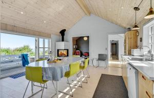 a kitchen with a table and yellow chairs in a room at Three-Bedroom Holiday Home In Knebel in Knebel