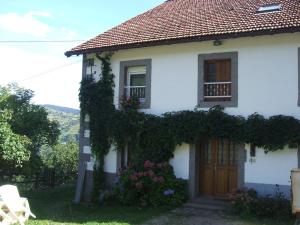 una casa bianca con edera sul lato. di La Ferme du Vieux Sapin a La Bresse