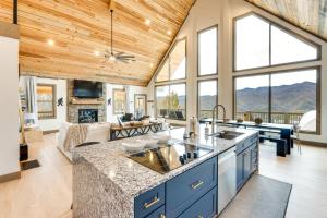 a kitchen with blue cabinets and a living room with mountains at Nantahala Forest Cabin with Fire Pits and Hot Tub! in Andrews