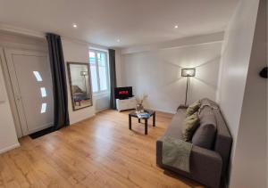 a living room with a couch and a table at Studio Moderne et Cosy à Miribel in Miribel