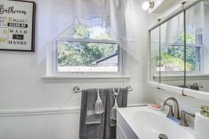 a white bathroom with a sink and a window at 3 Mi to Diamond Ballroom Home with Fenced Yard! in Oklahoma City +19 photos
