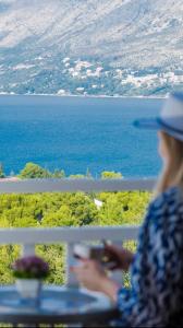 Eine Frau, die am Tisch sitzt und den Ozean ansieht. in der Unterkunft Villa Nick in Cavtat