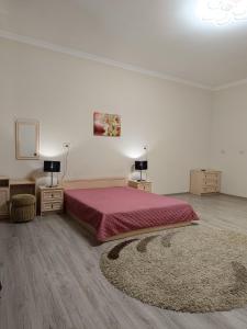 una camera con un letto e due tavoli e un tappeto di 2-х кімнатна квартира в центрі міста, поруч з Кобилянською вулицею a Černivci