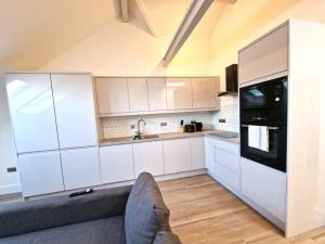 a kitchen with white cabinets and a couch at Alberton Apartments - Spacious - Newly Renovated in Bristol