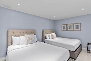 2 letti in una camera da letto con pareti bianche di Cozy 2br 2ba Retreat at Beachfront Resort, Heated Pool! a South Padre Island