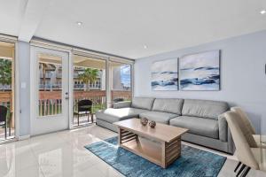ein Wohnzimmer mit Sofa und Tisch in der Unterkunft Beachfront Resort 2BR Condo 3 Pools, Heated Pool, Kids Pool & Jacuzzi in South Padre Island