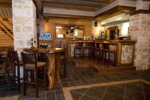 Eine Bar in einem Restaurant mit Holzhockern in der Unterkunft Lithos in Áyios Nikólaos