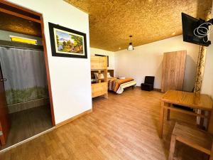 a room with a bedroom with a bed and a table at Tambo Lodge Canta in Canta