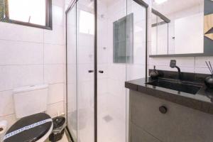 a bathroom with a shower and a toilet and a sink at Apartamento Smart Encantador in Maringá