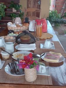 Una mesa de madera con platos de comida encima. en Flor da Mata- Ilha das Canárias, en Araioses