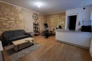 a living room with a couch and a table at Le QG in Saint-André-de-Cubzac